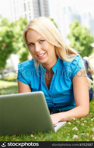 Woman using laptop in city park