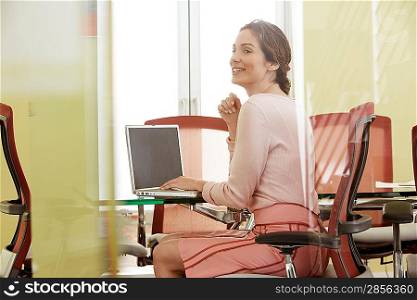 Woman using laptop in conference room