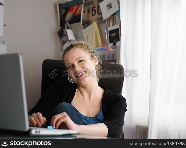 Woman using laptop sitting at office