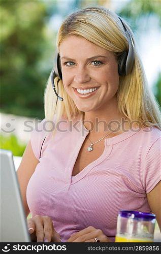 Woman Using Laptop Wearing Headset