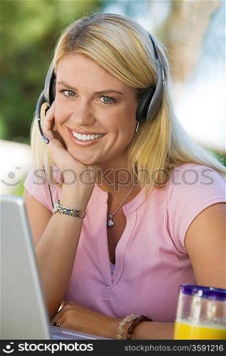 Woman Using Laptop Wearing Telephone Headset