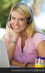 Woman Using Laptop Wearing Telephone Headset