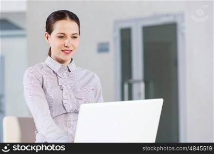 Woman using laptop. Young pretty girl in casual sitting and using laptop