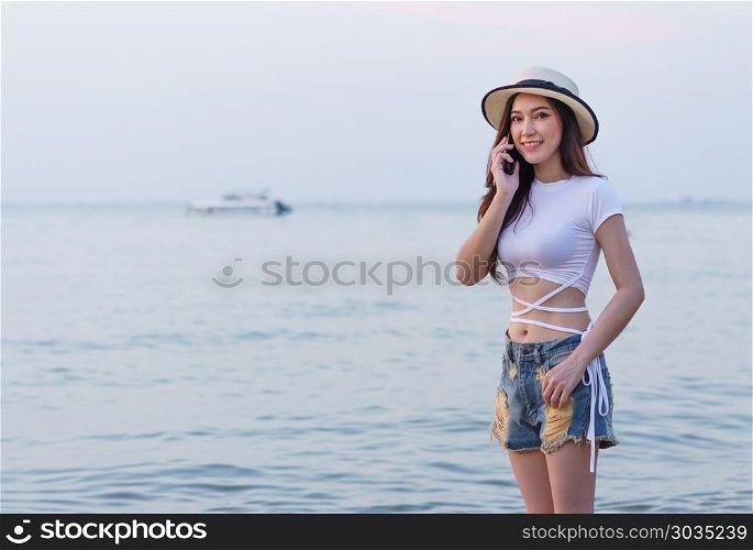 woman using mobile phone on the sea beach. beautiful woman using mobile phone on the sea beach
