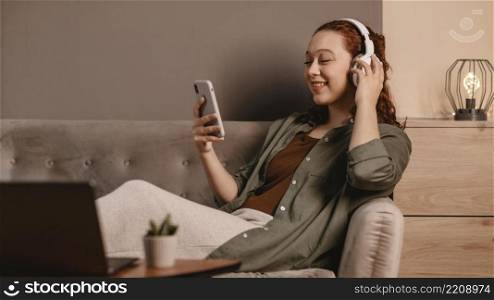 woman using modern headphones smartphone sofa home
