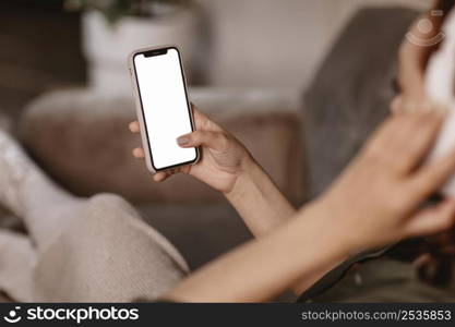 woman using modern smartphone headphones sofa home