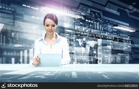 Woman using modern technologies. Businesswoman sitting at table with tablet pc against high tech blue background