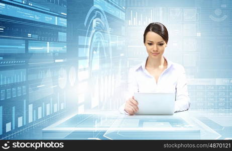 Woman using modern technologies. Businesswoman sitting at table with tablet pc against high tech blue background