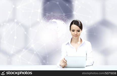 Woman using modern technologies. Businesswoman sitting at table with tablet pc against high tech blue background