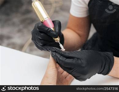 woman using nail file client wearing gloves