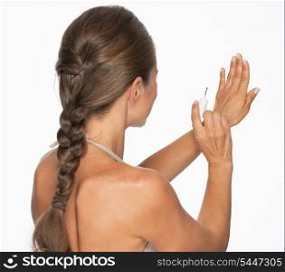 Woman using nail polish . rear view