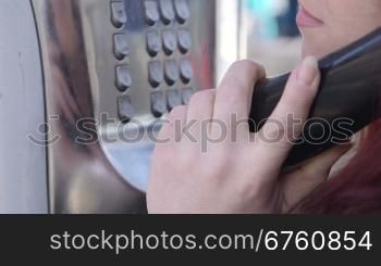 Woman using outdoor public call box