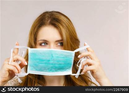 Woman using protective face mask, covering mouth. Coronavirus prevention. Healthcare medical hygiene concept.. Female using protective face mask.
