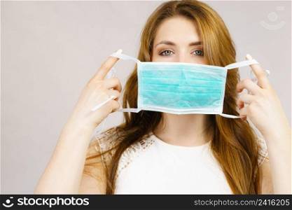 Woman using protective face mask, covering mouth. Coronavirus prevention. Healthcare medical hygiene concept.. Female using protective face mask.