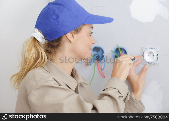 woman using screw driver during socket installation