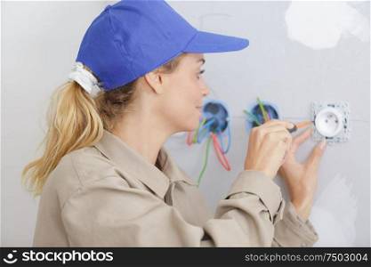 woman using screw driver during socket installation