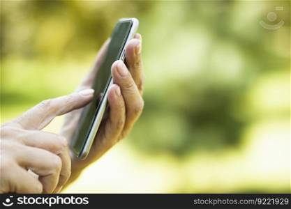 Woman using smart phone with blank black screen at outdoor with nature background