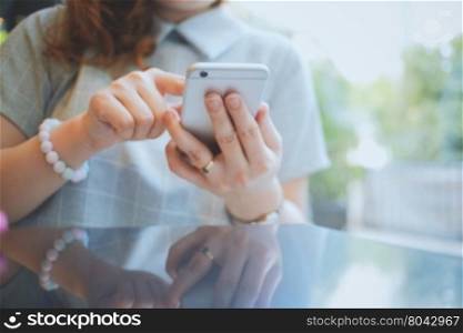 Woman using smartphone or mobile phone in the cafe