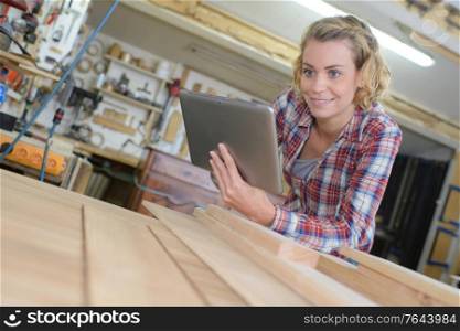 woman using tab and looking at wooden planks