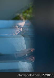 Woman using tablet computer at home, close up shot through window