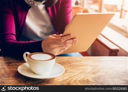 woman using tablet computer in coffee shop with vintage tone.