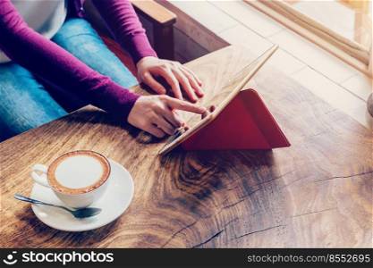 woman using tablet computer in coffee shop with vintage tone.