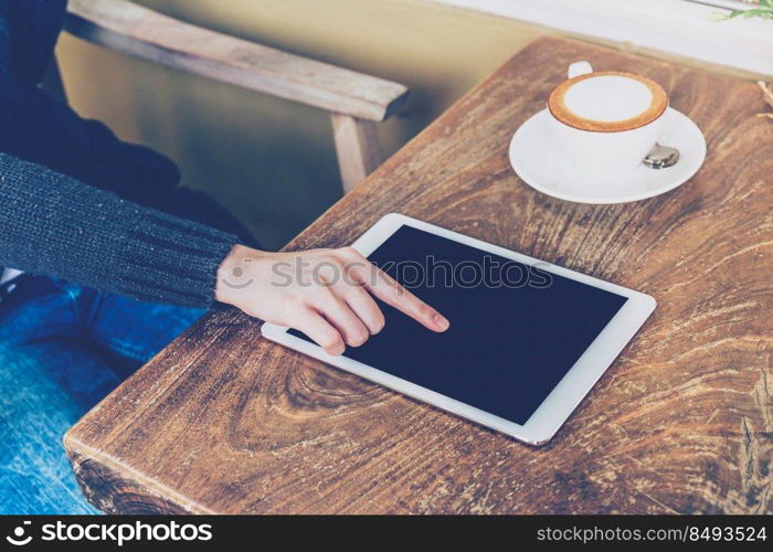 Woman using tablet in coffee shop with vintage tone.