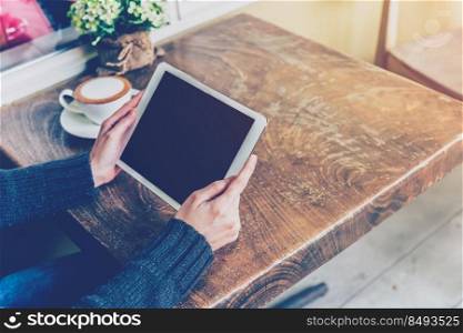 Woman using tablet in coffee shop with vintage tone.