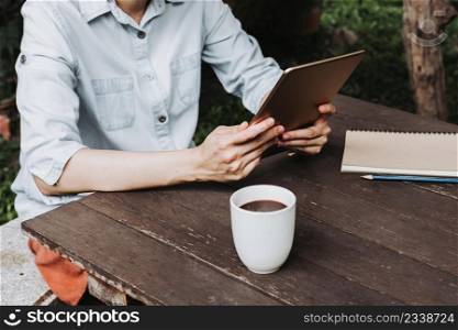 woman using tablet on wooden table