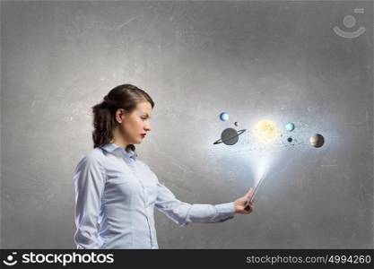 Woman using tablet pc. Young businesswoman with tablet and planets of space spinning around