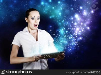 Woman using tablet pc. Young woman looking with surprise in tablet pc