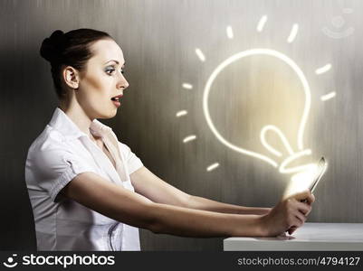 Woman using tablet pc. Young woman looking with surprise in tablet pc