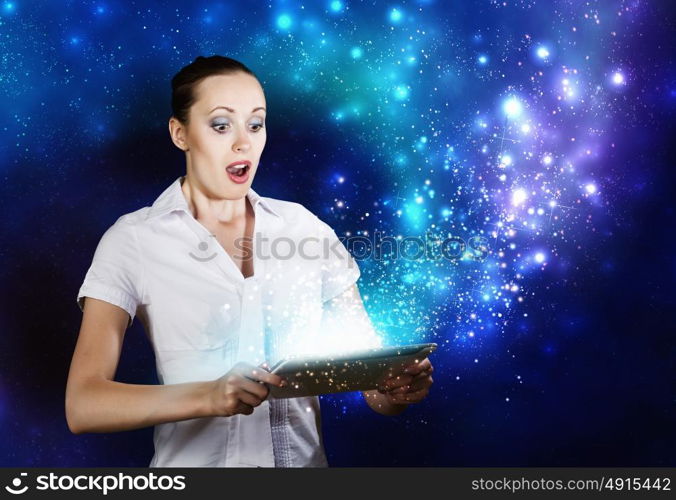 Woman using tablet pc. Young woman looking with surprise in tablet pc