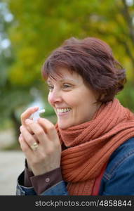 Woman using throat spray in cold season