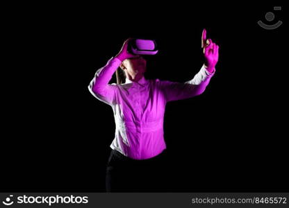 Woman Using Virtual Reality Simulator And Gesturing During Training.. Businesswoman Using Virtual Reality Goggles Gesturing While Taking Professional Training. Light Falling On Woman Wearing Modern Simulator And Presenting Creative Technology