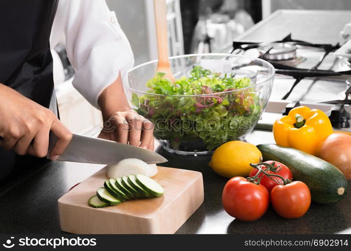 woman vegan cooking healthy food and preparing salad for dinner in a kitchen