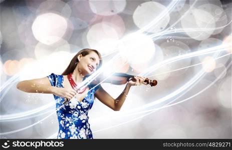 Woman violinist. Young attractive woman in blue dress playing violin