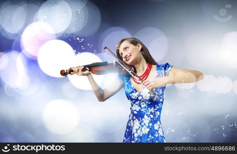 Woman violinist. Young attractive woman in blue dress playing violin