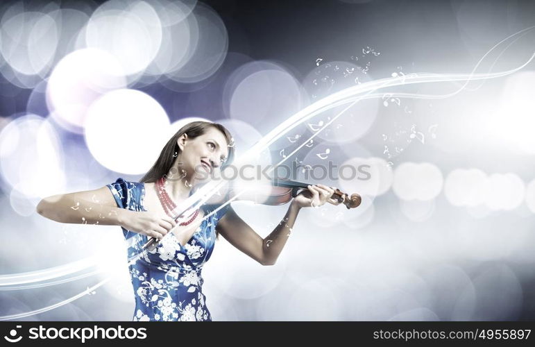 Woman violinist. Young attractive woman in blue dress playing violin