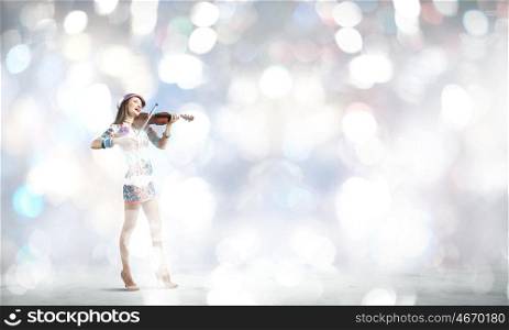 Woman violinist. Young attractive woman in colored dress playing violin