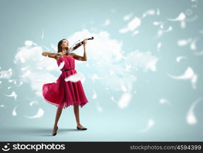 Woman violinist. Young attractive woman in red dress playing violin