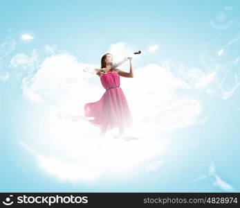 Woman violinist. Young attractive woman in red dress playing violin