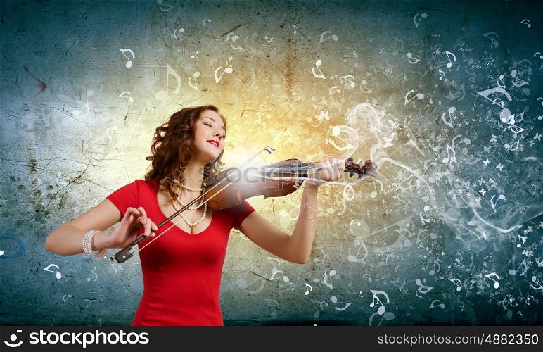 Woman violinist. Young attractive woman in red dress playing violin