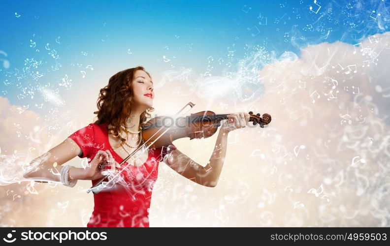 Woman violinist. Young attractive woman in red dress playing violin