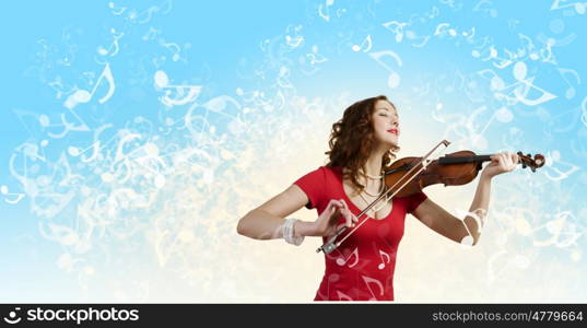 Woman violinist. Young pretty woman in red dress playing violin