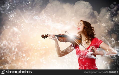 Woman violinist. Young pretty woman in red dress playing violin