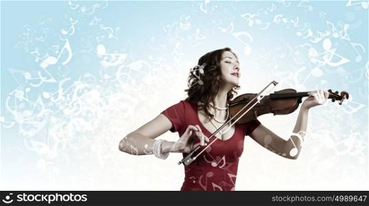 Woman violinist. Young pretty woman in red dress playing violin