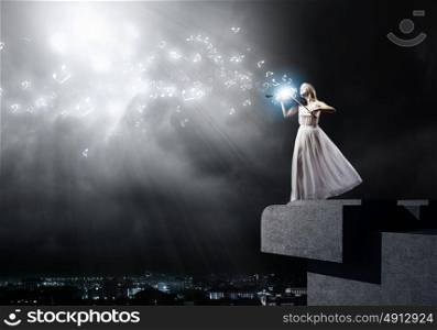 Woman violinist. Young woman in white dress playing violin at night