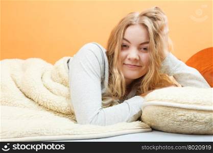Woman waking up in bed in morning after sleeping. Woman waking up in bed in the morning after sleeping. Young girl laying under wool blanket.