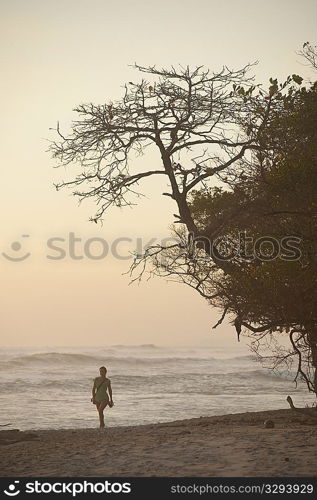 Woman walking along Mal Pais coastline in San Jose Costa Rica